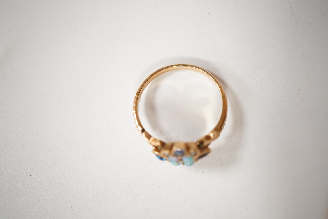 A late Victorian yellow metal, sapphire, opal and seed pearl cluster set dress ring, (one stone a paste replacement), size N, gross weight 2.2 grams.